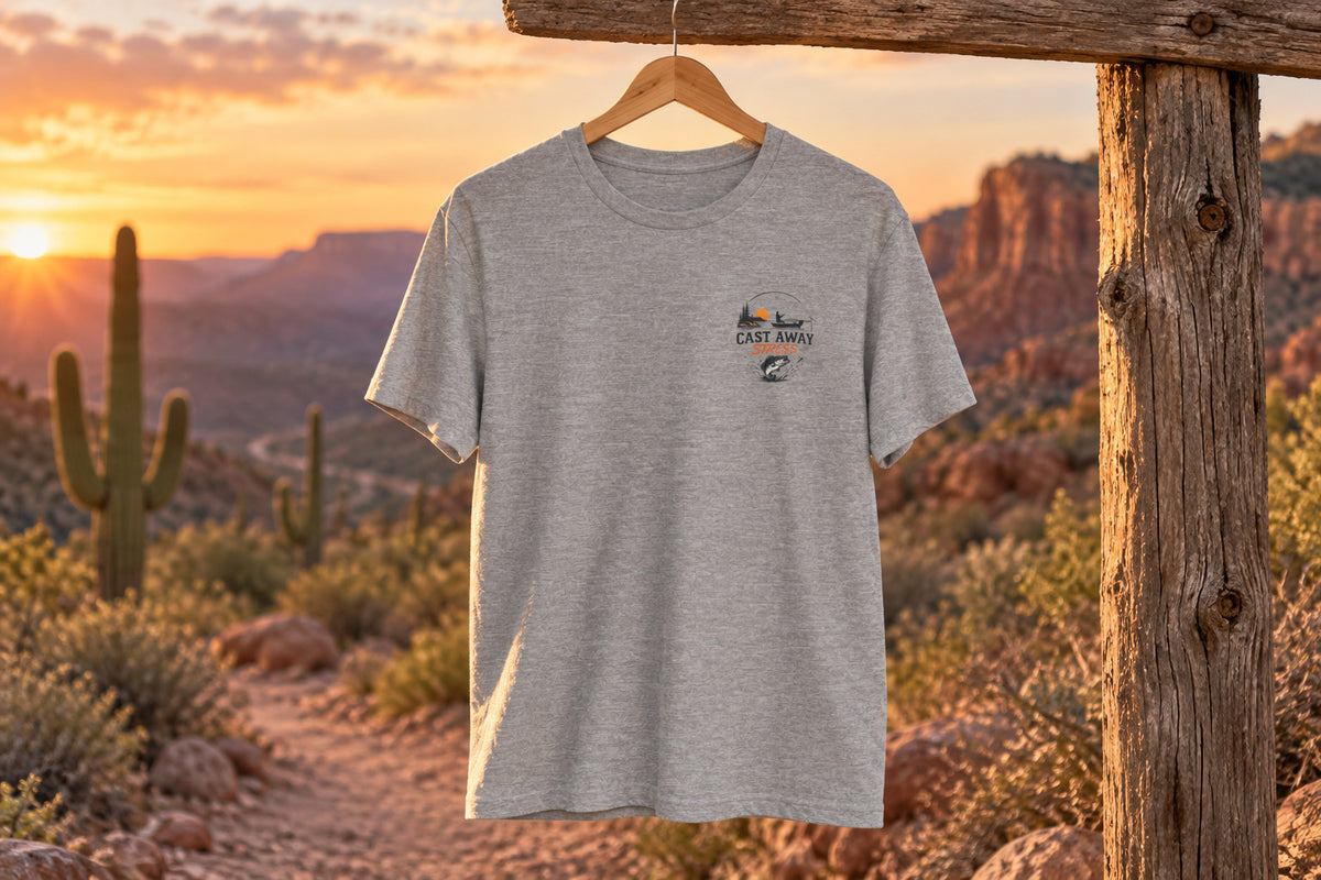 Fishing T-Shirt - "Cast Away" Graphic Tee with Sunset & Bass - Athletic Heather on a wooden hanger outdoors | MR7ART